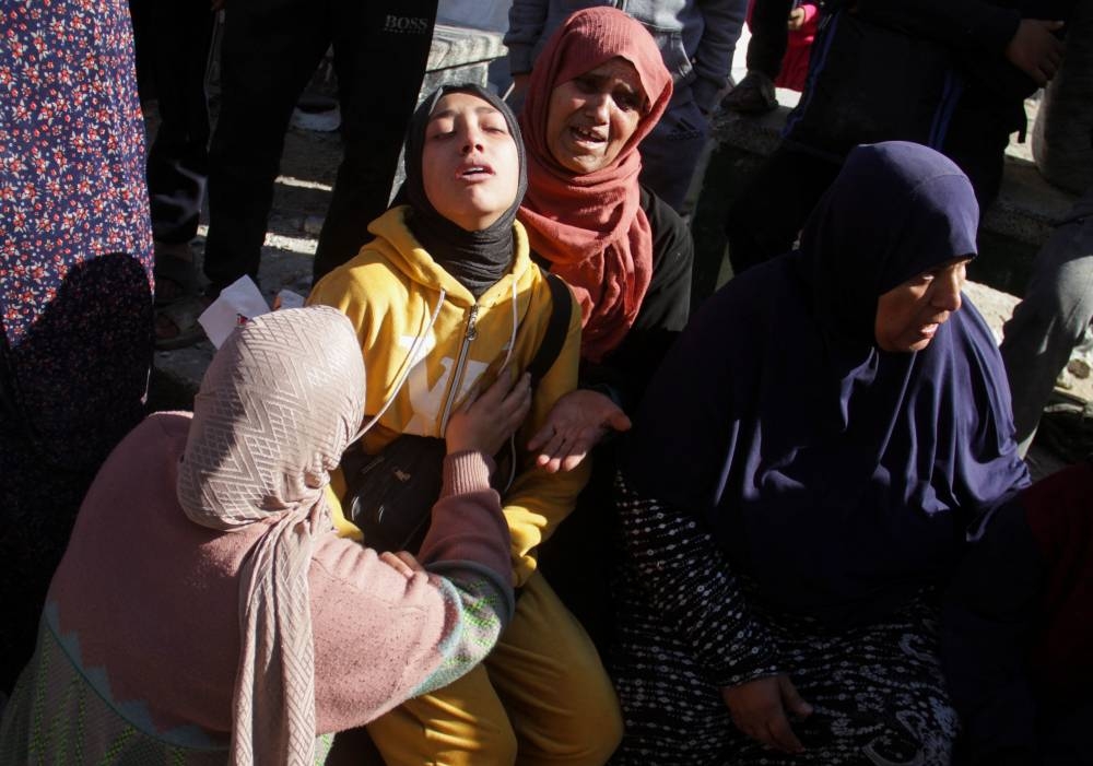 Palestinians react at the site of an Israeli strike on a school sheltering displaced people, in Gaza City, on Saturday. REUTERS
