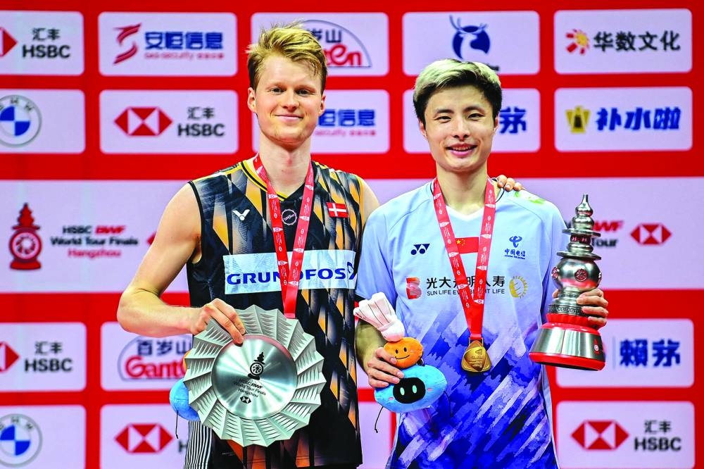 China’s Shi Yuqi (right) poses with his trophy after winning the men’s singles final match against Denmark’s Anders Antonsen (left) at the BWF Badminton World Tour Finals in Hangzhou, in eastern China’s Zhejiang province, yesterday. (AFP)