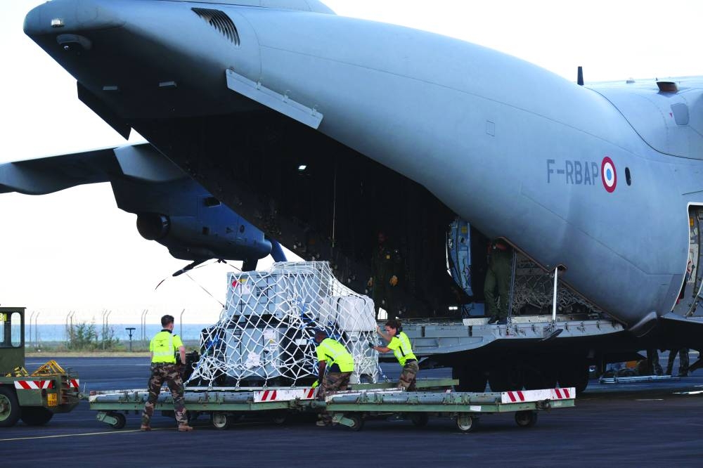 French military unload medical and emergency equipment from the A440M military aircraft, aboard of which rescue teams were transported in an emergency response, bringing aid to Mayotte. (AFP)