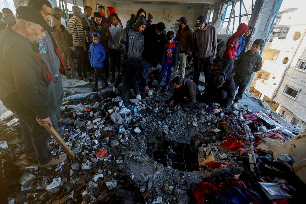 Palestinians inspect the damage in the aftermath of an Israeli strike on a school sheltering displaced people, in Khan Younis in the southern Gaza Strip, on Monday. REUTERS
