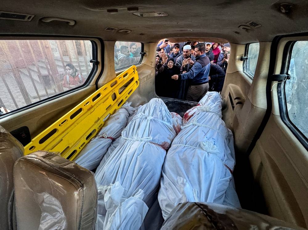 Mourners react next to the bodies of Palestinians killed in Israeli strikes kept inside a vehicle during their funeral, in Khan Younis in the southern Gaza Strip, on Monday. REUTERS