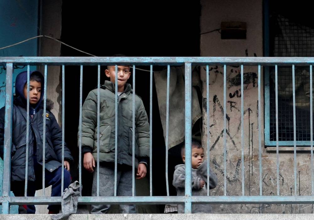 Palestinian children look on from a balcony in the aftermath of an Israeli strike on a school sheltering displaced people, in Khan Younis in the southern Gaza Strip, on Monday. REUTERS