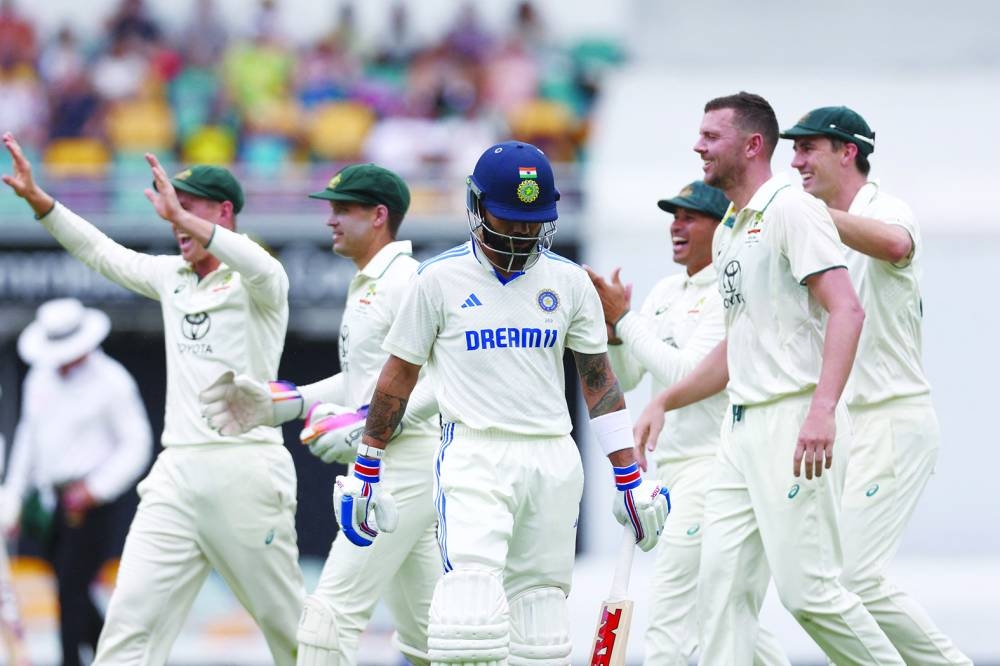 India’s Virat Kohli (centre) walks off the field as Australia’s Josh Hazlewood (second right) celebrates his wicket with teammates on day three of the third Test at The Gabba in Brisbane on Monday. (AFP) 