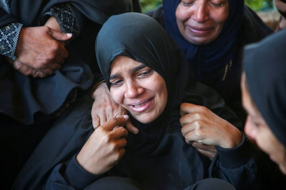 Mourners react during the funeral of Palestinian woman Hanaa Mansour, who was killed in an Israeli strike on a tent camp sheltering displaced people, at Nasser hospital in Khan Younis, southern Gaza Strip, on Wednesday. REUTERS