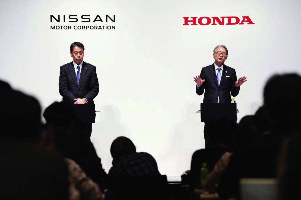 Makoto Uchida, president and CEO of Nissan Motor, and Toshihiro Mibe, Honda Motor president and CEO, attend a joint press conference in Tokyo (file). Honda and Nissan are in talks to deepen ties, including a possible merger, the clearest sign yet of how Japan's once seemingly unbeatable auto industry is being reshaped by challenges from Tesla and Chinese rivals.