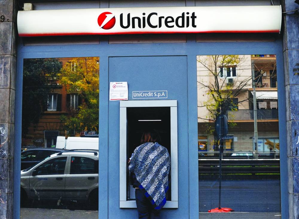 A person uses an ATM at a UniCredit bank branch in Rome.
