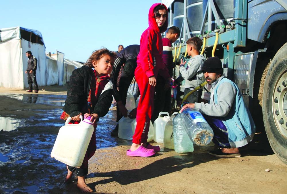 Palestinians wait to collect water in Khan Younis in the southern Gaza Strip Thursday 