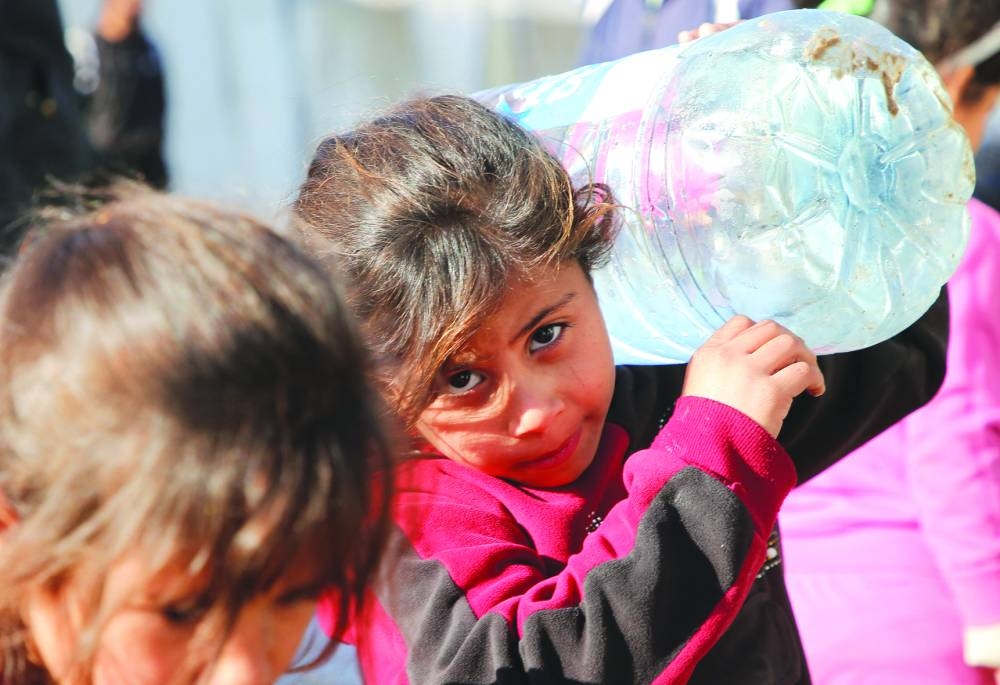 A Palestinian child carries a water container in Khan Younis in the southern Gaza Strip Thursday 