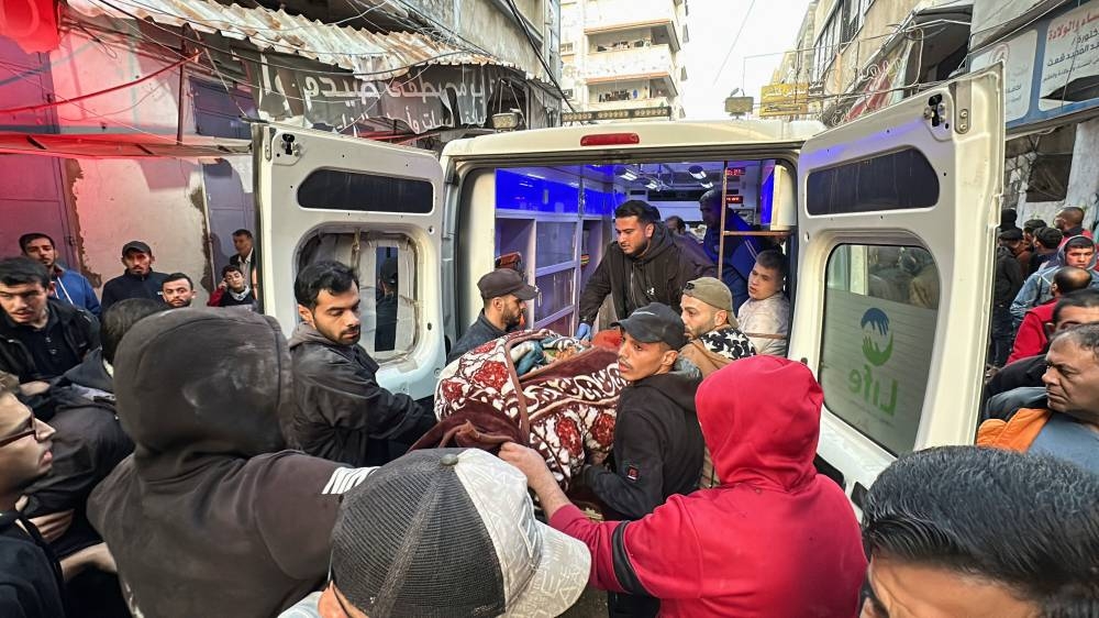 Palestinians carry a body at the site of an Israeli strike on an apartment, in Nuseirat, central Gaza Strip, on Friday. REUTERS