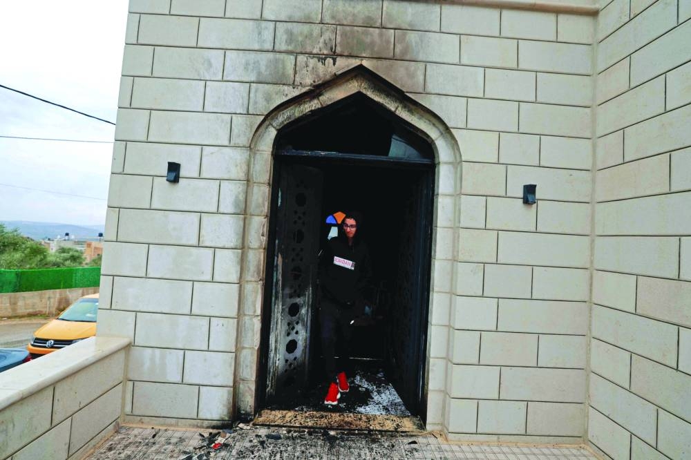 A Palestinian inspects the damage done to a mosque, after a reported attack by Israeli settlers, in the town of Marda near the West Bank city of Salfit, yesterday.