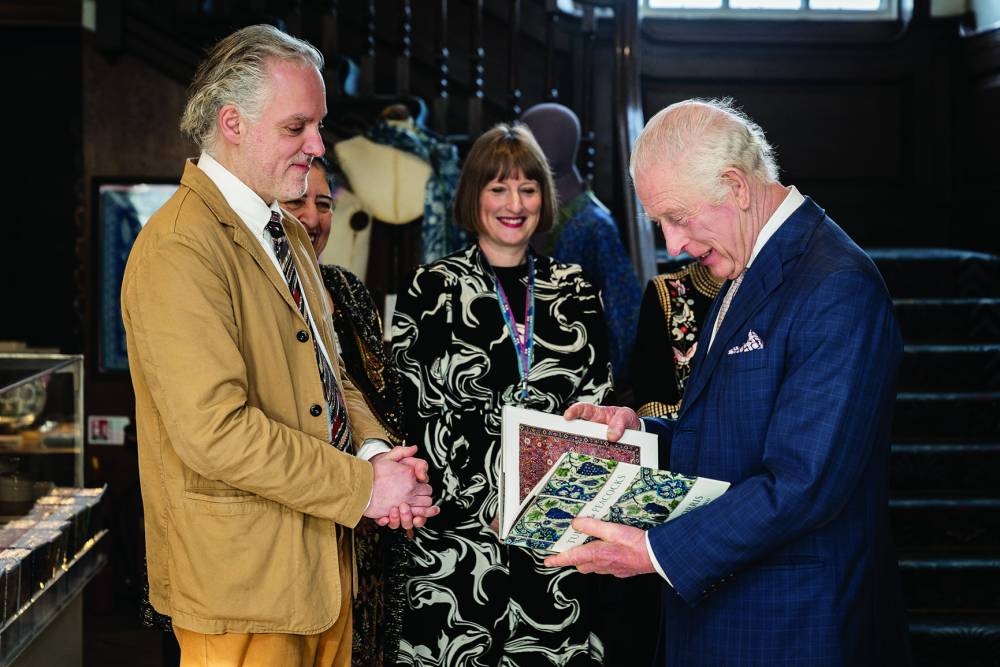 King Charles III is presented with a book by Hadrian Garrard during a visit to the Islamic World exhibition at the William Morris Gallery in London on Friday.