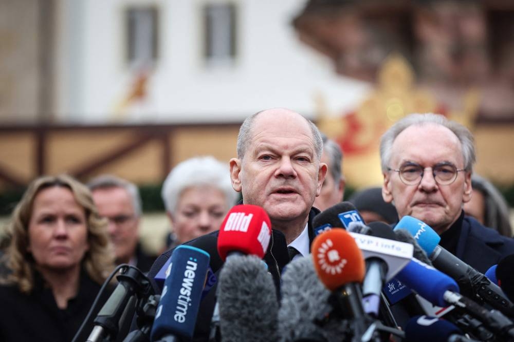 German Chancellor Olaf Scholz (C) speaks to the press as State Premier of Saxony-Anhalt Reiner Haseloff (R) and German Minister for the Environment, Nature Conservation, Nuclear Safety and Consumer Protection Steffi Lemke (L) look on during their visit to the site of a car-ramming attack on a Christmas market in Magdeburg, eastern Germany, on Saturday. AFP