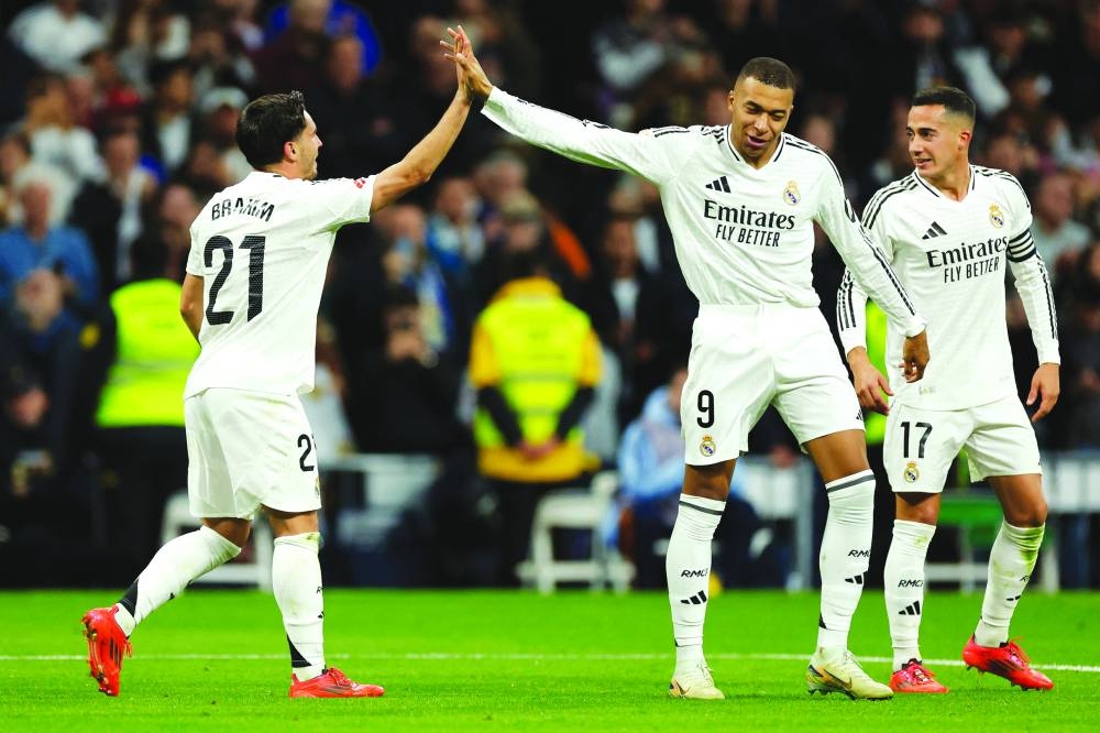 Real Madrid’s forward Kylian Mbappe (second from left) and teammate Brahim Diaz (left) celebrate a goal during the La Liga match against Sevilla at the Santiago Bernabeu stadium in Madrid yesterday. (AFP)