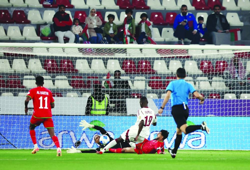 Qatar’s Almoez Ali scores against Oman during the Arabian Gulf Cup match in Sulaibikhat, Kuwait, on Tuesday. (Reuters)
