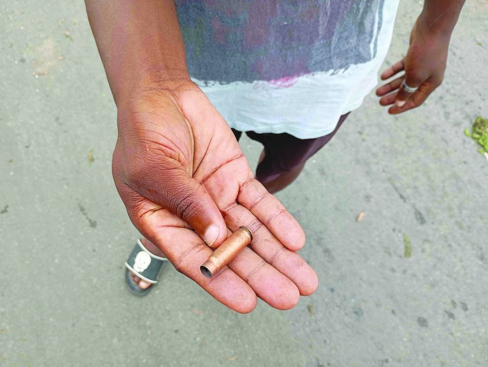 A man holds a spent bullet casing on a street in Maputo yesterday.