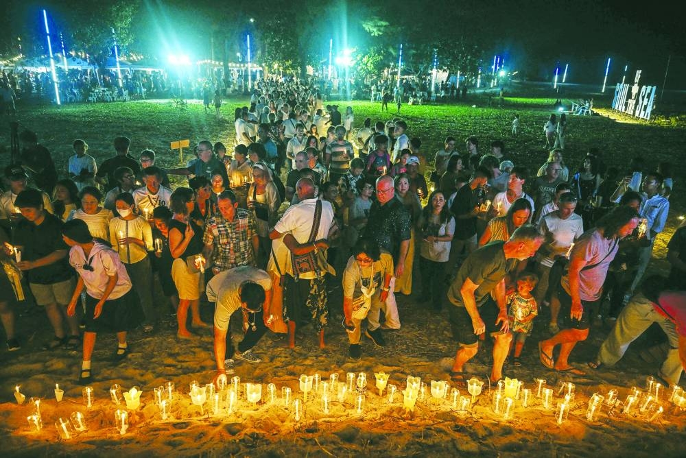 Mourners place candles on the beach at the Ban Nam Khem Tsunami Memorial Park in the southern Thai province of Phang Nga on Thursday.