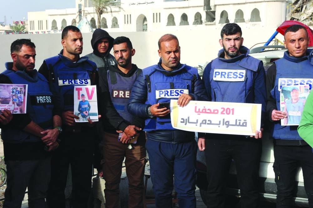 Members of the press stand in solidarity after an Israeli missile hit a media broadcast truck in Nuseirat on Thursday in Gaza City