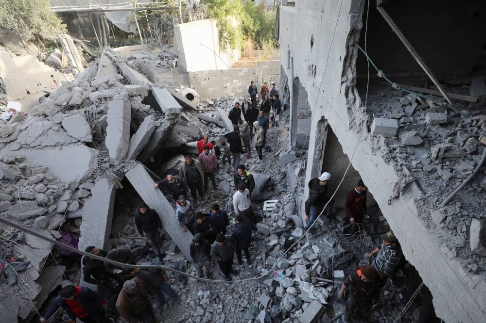 Palestinians inspect the site of an Israeli airstrike on a house, in Gaza City, on Friday. REUTERS