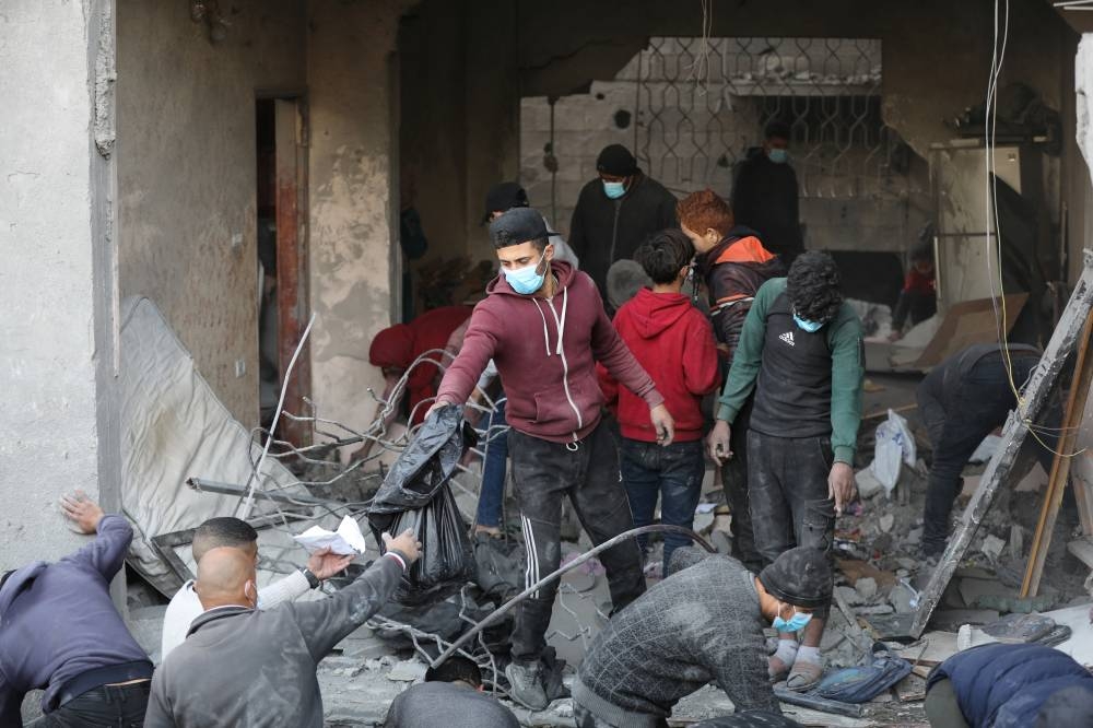 Palestinians search for casualties at the site of an Israeli airstrike on a house, in Gaza City, on Friday. REUTERS