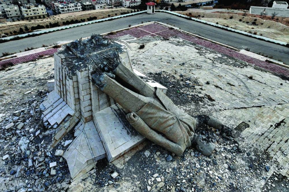 This aerial view shows the remains of a destroyed monument to Syria’s late president Hafez al-Assad, father of ousted president Bashar al-Assad who died in 2000, in Deir Attiyah in the countryside of Damascus yesterday. The monument in Deir Attiyah was the largest statue of Hafez al-Assad until it was destroyed on December 8 after Bashar al-Assad fled the country and rebels took the capital Damascus. (AFP)