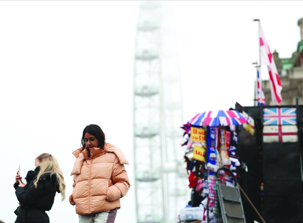 
Tourists walk by the London Eye during foggy weather. 