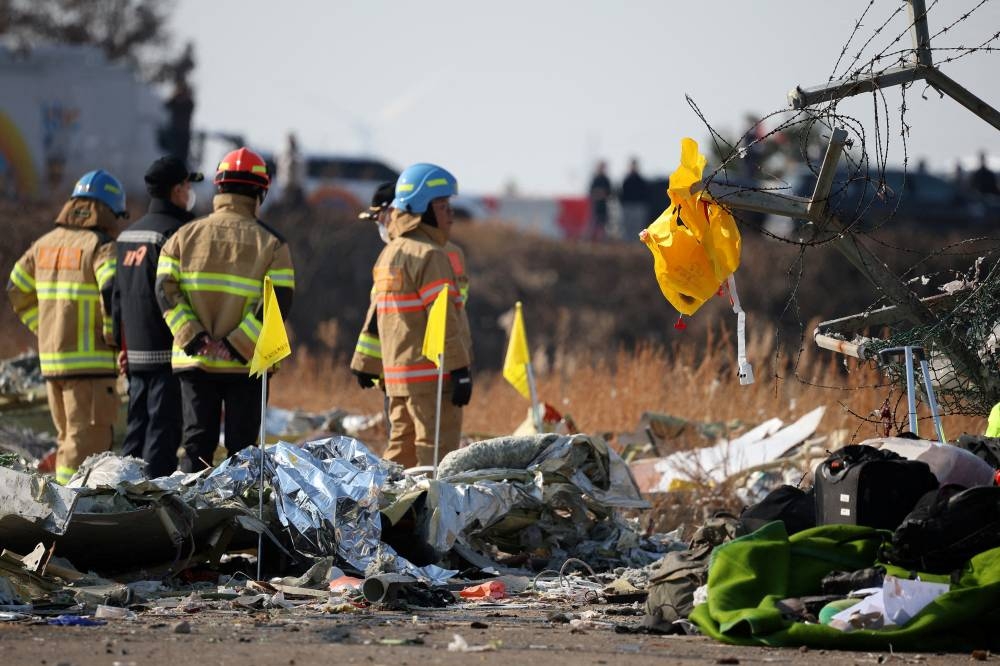 A life jacket hangs on fencing next to the wreckage at Muan International Airport, on Sunday. REUTERS
