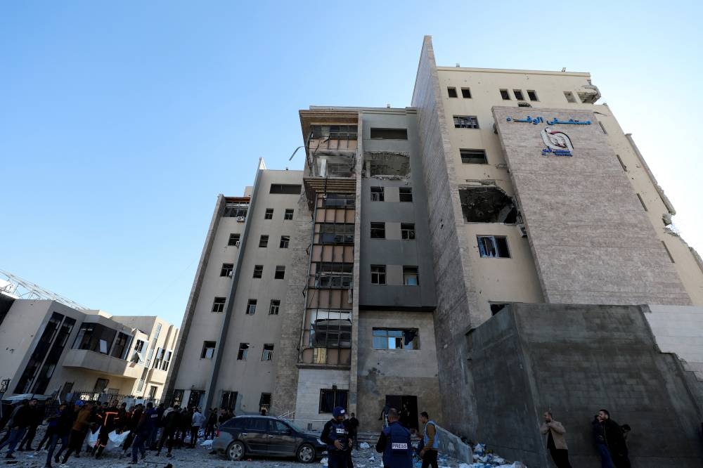 Palestinians inspect the site of an Israeli strike on Al-Wafaa hospital, in Gaza City, on Sunday. REUTERS