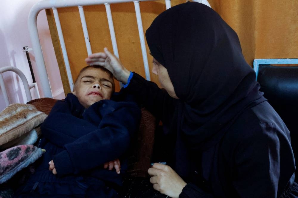 Palestinian boy Mu'ath Mohamed Abu Hagag, who doctors said is malnourished, is attended to by his mother as he lies on a bed receiving treatment at the ICU of Nasser hospital in Khan Younis in the southern Gaza Strip on December 7. REUTERS