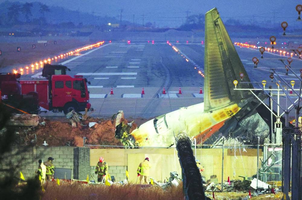 Rescuers work near the wreckage of the Jeju Air aircraft that went off the runway and crashed at Muan International Airport,  South Korea.