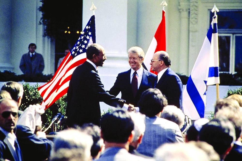 
President Carter (centre) congratulates Egyptian president Anwar al-Sadat (left) and Israeli premier Menachem Begin as they shake hands on March 26, 1979 on the north lawn of the White House in Washington, DC, after signing the historic US-sponsored peace treaty between Israel and Egypt. (AFP) 
