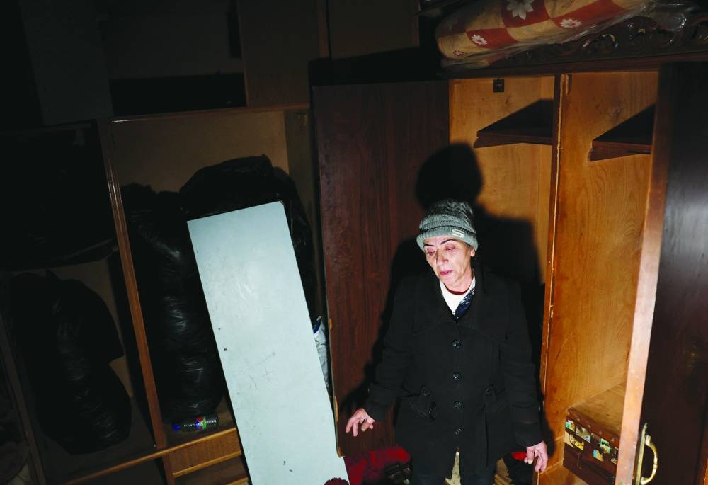 Eidye Zaitoun, 52, who is Alwaite and her son a soldier in the fourth division at the army under the Assad regime, stands next to her belongings before moving out of her home at Muadamiyat al-Sham,  following evacuation orders from factions of Hayat Tahrir al-Sham (HTS), on the outskirts of Damascus, in Syria.