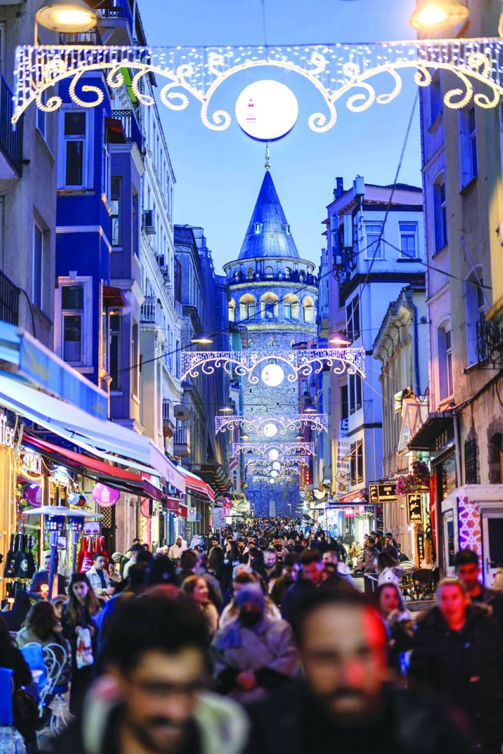 
People walk on Istiklal street near the Galata Tower on the eve of the New Year in Istanbul. (AFP) 