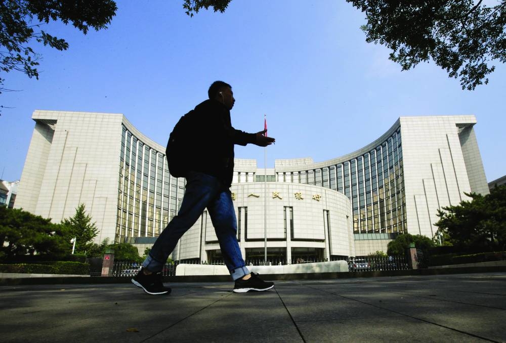 A man walks past the headquarters of the People's Bank of China in Beijing. The PBoC previously flagged it could free more cash for banks by cutting the reserve requirement ratio again one more time by the end of 2024. It’s now expected to make that move in the first quarter of this year, keeping officials’ powder dry on a closely-watched tool that could alleviate the negative impact from fresh US tariffs.