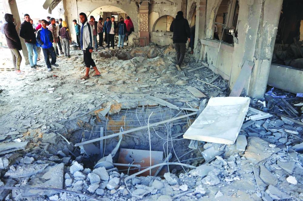 Palestinians check a crater caused by an Israeli strike that hit an administrative building in Khan Younis in the southern Gaza Strip on Thursday 