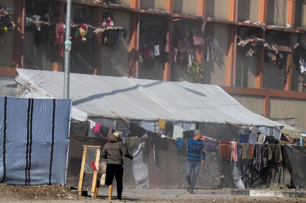 Palestinians run following an Israeli strike in Deir Al-Balah in the central Gaza Strip, on Friday. REUTERS