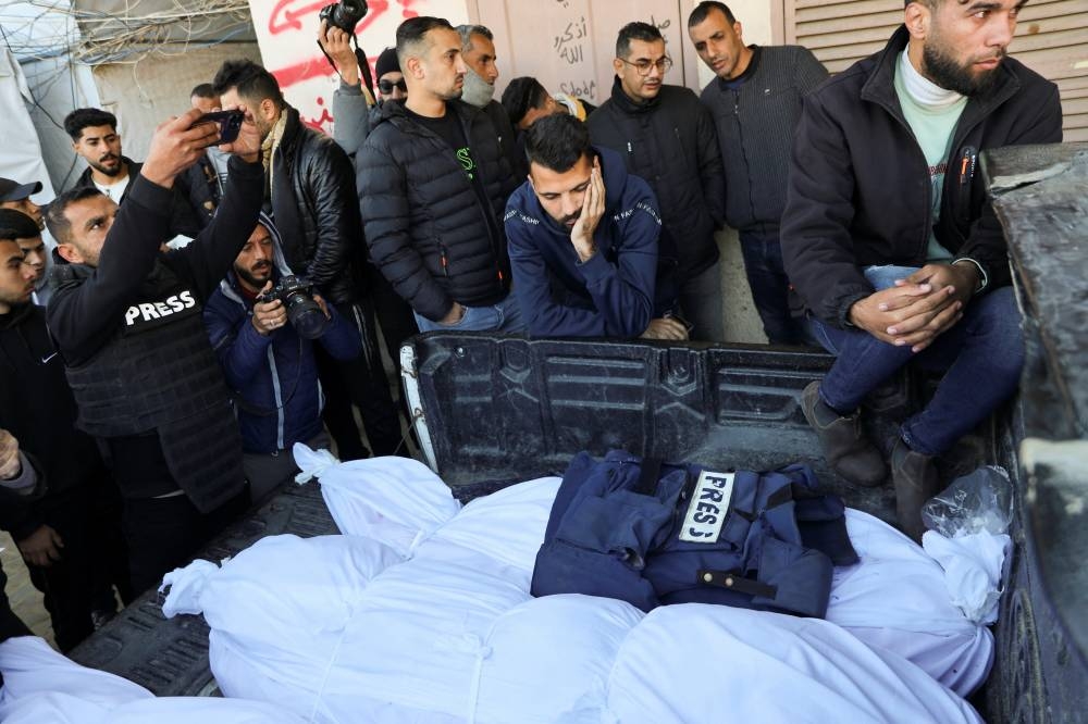 Mourners gather around the bodies of Palestinians, including journalist Omar Al-Derawi, who were killed in Israeli strikes, at Al-Aqsa Martyrs Hospital in Deir Al-Balah in the central Gaza Strip, on Friday. REUTERS
