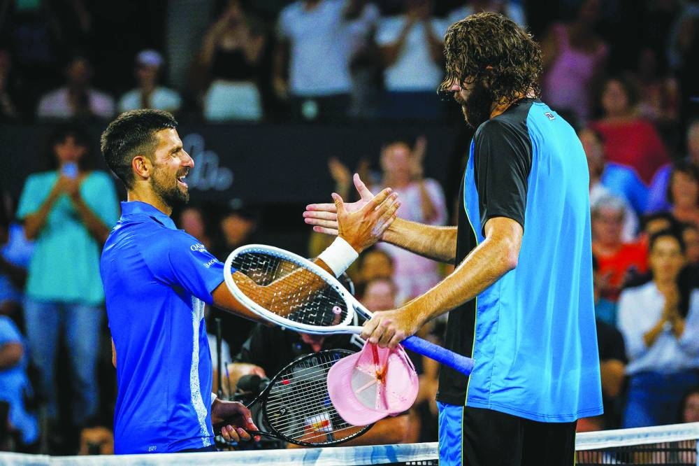 Winner Reilly Opelka of the United States (right) and Serbia’s Novak Djokovic shake hands at the net after their singles quarter-final at the Brisbane International on Friday. (AFP)