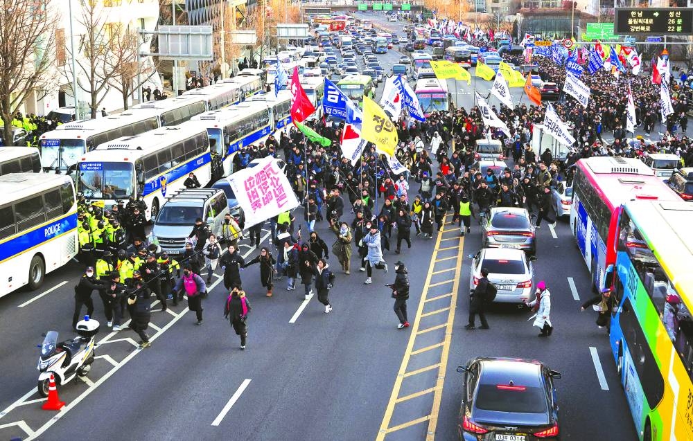 Anti-Yoon protesters block traffic as they march towards impeached South Korean President Yoon Suk-yeol’s official residence on Friday.
