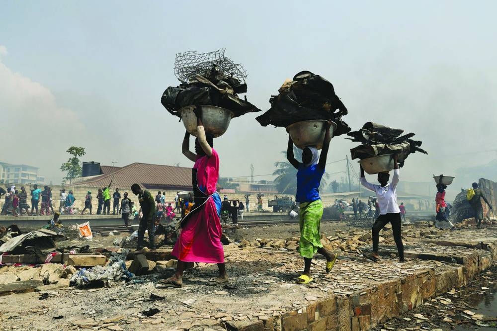 
People try to salvage items from the burned down secondhand clothing market at Kantamanto in Accra. 