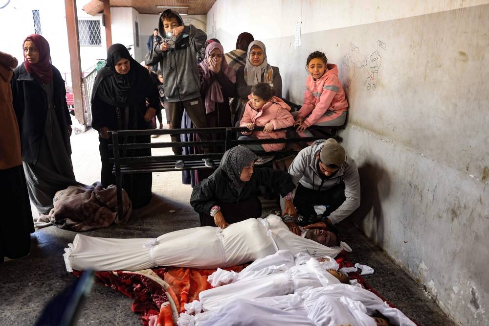 Relatives mourn over the bodies of members of the Ghoula family at the Al-Ahli Arab hospital, also known as the Baptist hospital, after their home was hit in an Israeli strike in the Shujaiya neighbourhood of Gaza City, in the northern Gaza Strip on Saturday. AFP