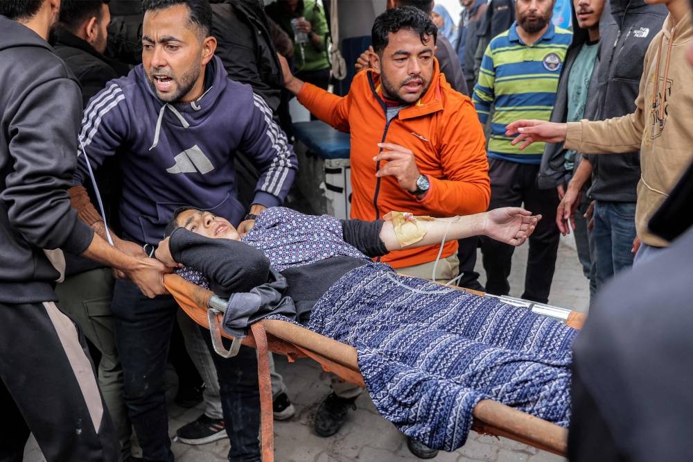 An injured woman is carried on a stretcher for care at the Ahli Arab hospital, also known as the Baptist hospital, in Gaza City on Saturday. AFP