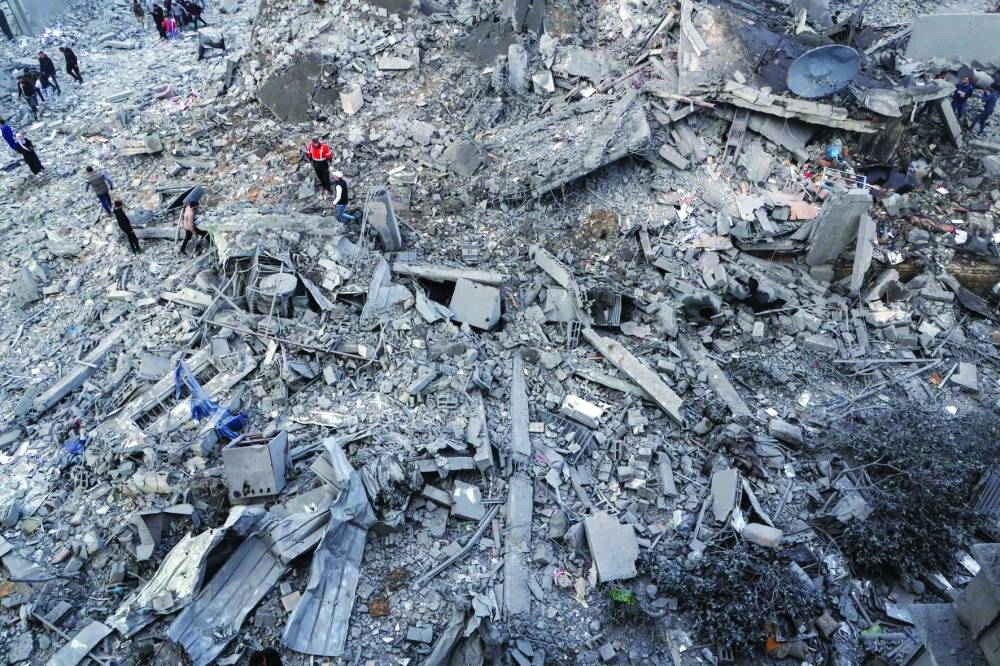 Palestinians gather at the site of an Israeli strike on houses, in Gaza City Saturday.