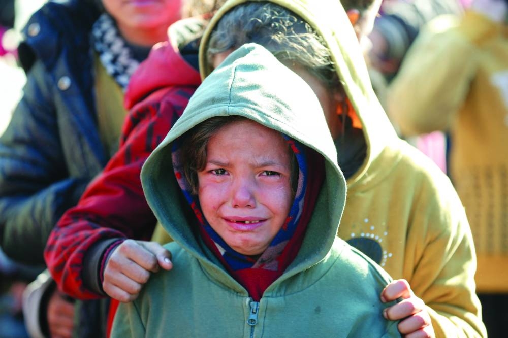 
A child reacts as Palestinians gather to receive food cooked by a charity kitchen, amid a hunger crisis, in Khan Younis in the southern Gaza Strip. (Reuters) 