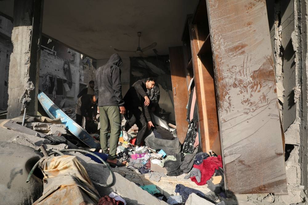 Palestinians inspect the site of an Israeli strike on a house, in Gaza City, on Sunday. REUTERS