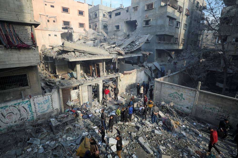 Palestinians gather at the site of an Israeli strike on a house, in Gaza City, on Sunday. REUTERS