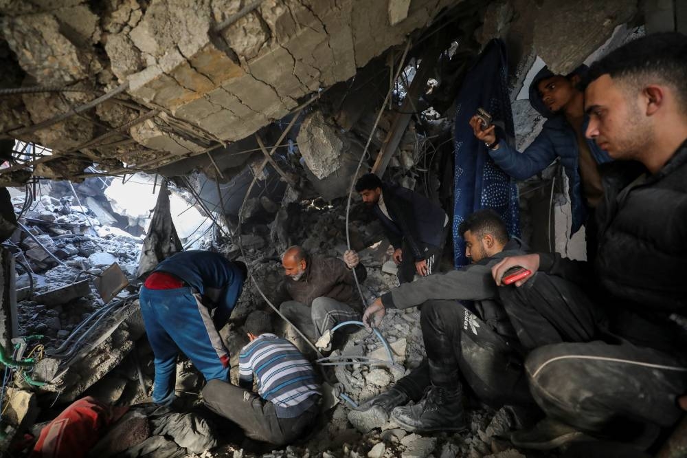 Palestinians search for casualties at the site of an Israeli strike on a house, in Gaza City, on Sunday. REUTERS