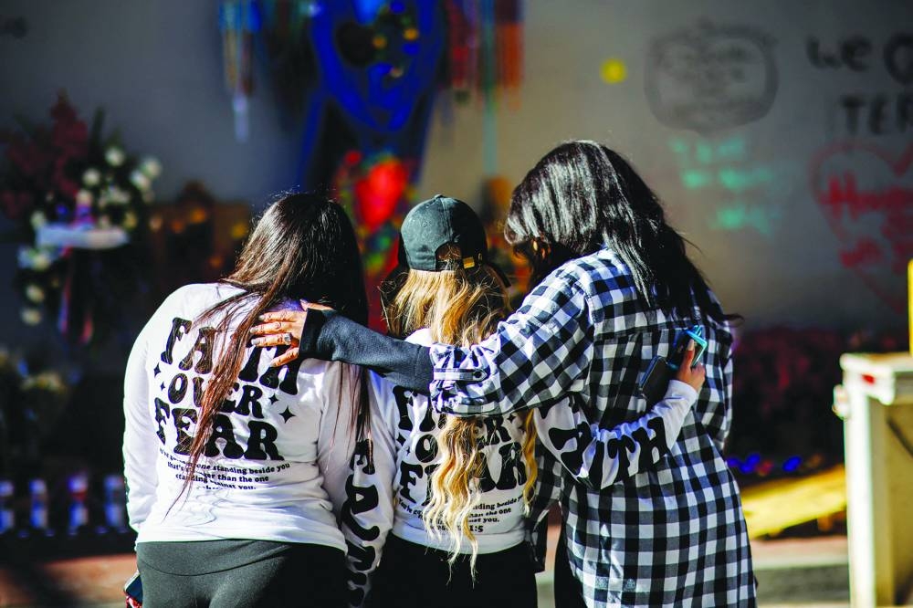 
Women pray next to a makeshift memorial for the victims at Bourbon Street two days after a US Army veteran drove his truck into the crowded French Quarter on New Year’s Day in New Orleans. (Reuters) 