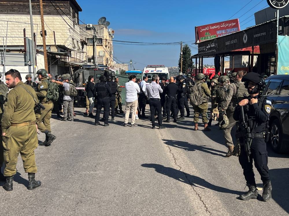 Israeli security and rescue personnel at the scene of a shooting attack on a car and bus where at least three Israelis were killed near Kedumim in the Israeli-occupied West Bank, on Monday. REUTERS