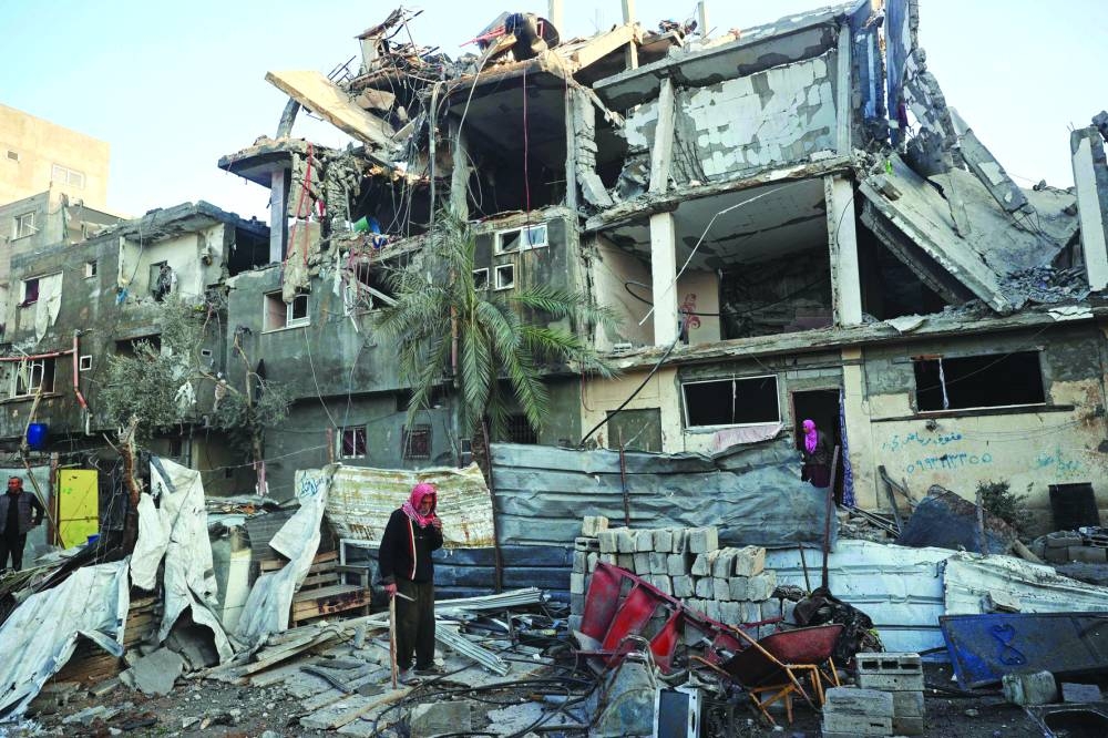 People look for their belongings amid the debris of a destroyed building following an Israeli air strike on Bureij camp in the central Gaza Strip Monday