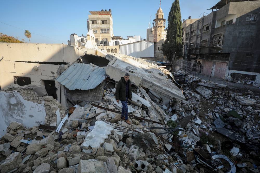 Palestinian Christian Ramez Al-Souri, whose three children and other family members were killed in an Israeli strike on a section of the Greek Orthodox Church of Saint Porphyrius in October 2023, stands atop the rubble at the site of the strike, in Gaza City, on Tuesday. REUTERS